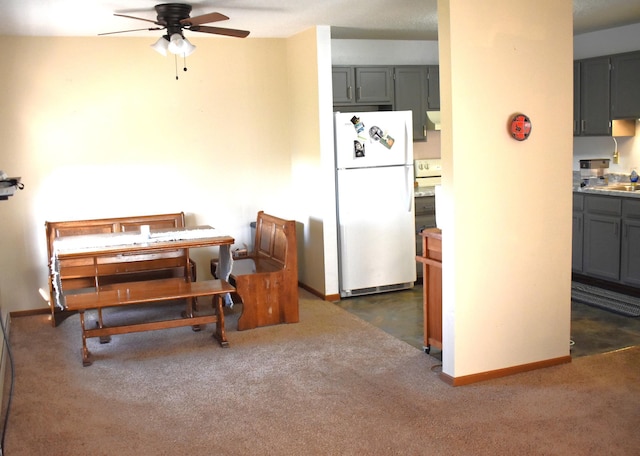 kitchen featuring ceiling fan, white fridge, and gray cabinetry