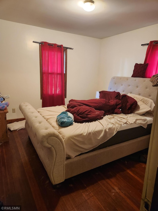 bedroom with dark wood-type flooring