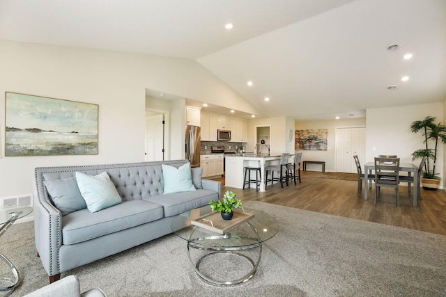 living room with lofted ceiling and hardwood / wood-style flooring