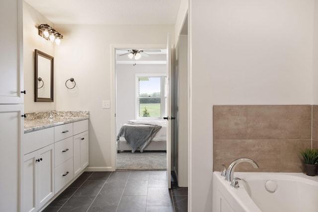 bathroom with a bathtub, vanity, ceiling fan, and tile patterned floors