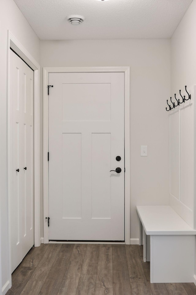 mudroom with a textured ceiling and dark wood-type flooring