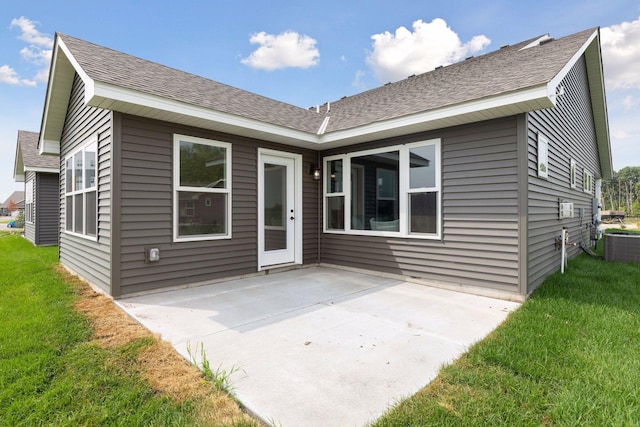 rear view of property featuring cooling unit, a lawn, and a patio area