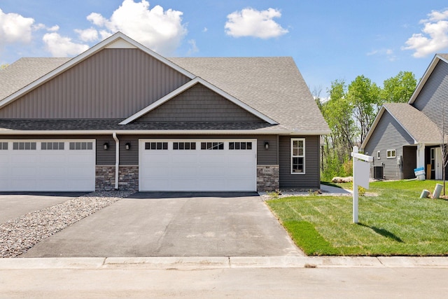 20092 Fitzgerald Trl N, Forest Lake, MN 55025 - craftsman-style home with stone siding, asphalt driveway, a shingled roof, a front lawn, and an attached garage