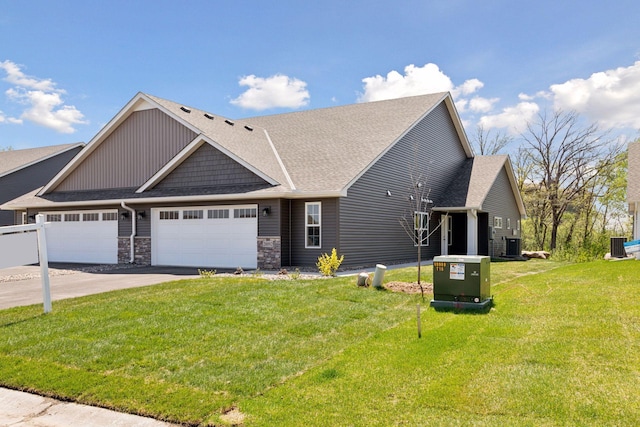 20092 Fitzgerald Trl N, Forest Lake, MN 55025 - view of front facade featuring a garage, a front yard, a shingled roof, asphalt driveway, and stone siding