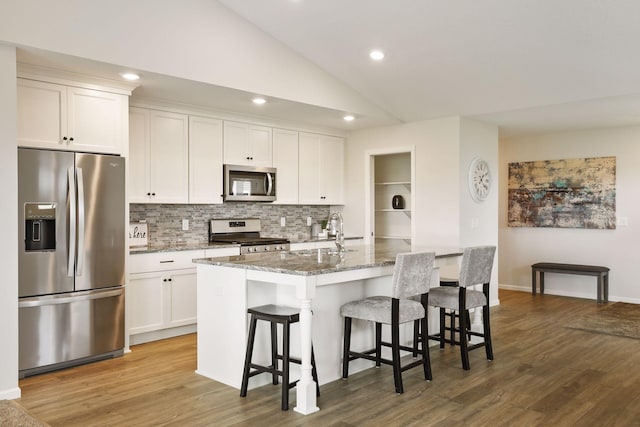 20092 Fitzgerald Trl N, Forest Lake, MN 55025 - kitchen with stainless steel appliances, a sink, tasteful backsplash, a kitchen island with sink, and stone countertops