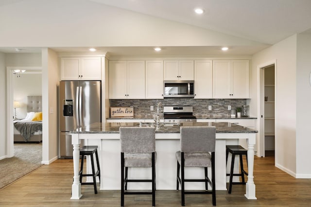 20092 Fitzgerald Trl N, Forest Lake, MN 55025 - kitchen featuring appliances with stainless steel finishes, a center island with sink, tasteful backsplash, white cabinetry, and a sink