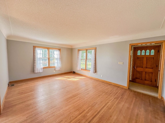 interior space featuring a textured ceiling and light hardwood / wood-style flooring