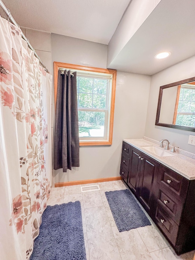 bathroom featuring tile patterned floors, walk in shower, and vanity