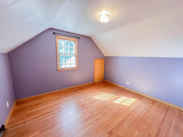 bonus room with lofted ceiling and light hardwood / wood-style floors