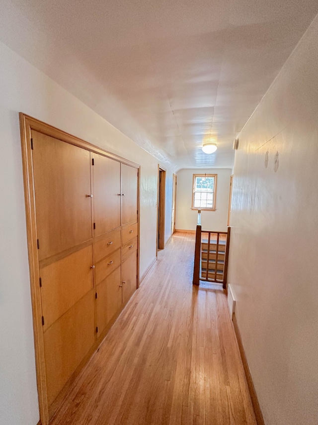 hall featuring a textured ceiling and light hardwood / wood-style floors