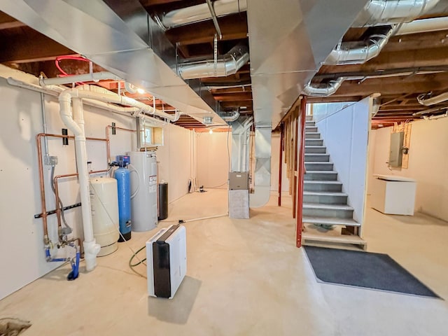 basement featuring heating unit, water heater, and electric panel