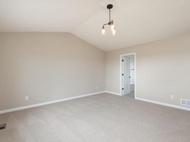 carpeted empty room with lofted ceiling