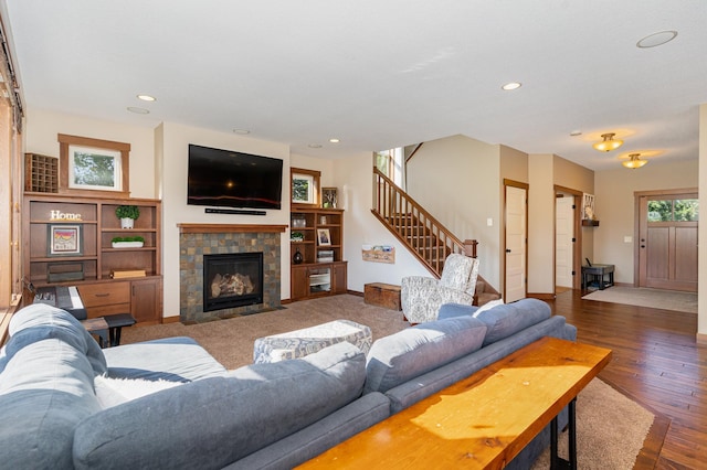 living room featuring dark wood-type flooring and a tile fireplace