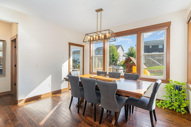 dining area with dark hardwood / wood-style floors, a chandelier, and a healthy amount of sunlight