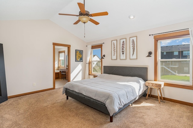 carpeted bedroom featuring ensuite bath, lofted ceiling, multiple windows, and ceiling fan