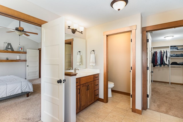 bathroom with lofted ceiling, ceiling fan, vanity, and toilet