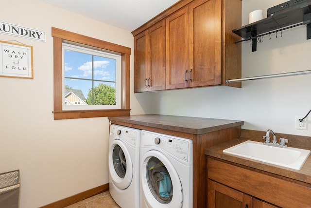 clothes washing area featuring washing machine and dryer, cabinets, sink, and light tile patterned floors