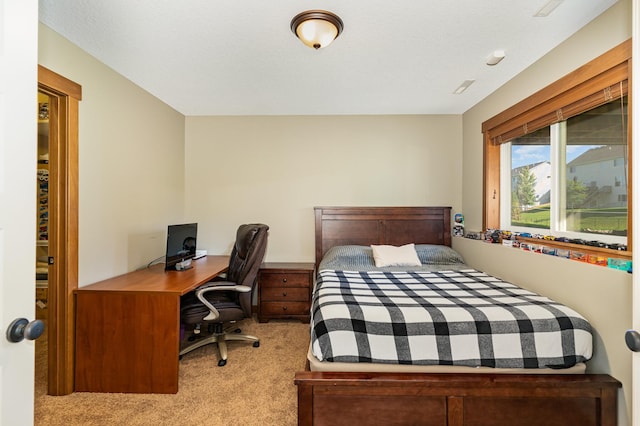 bedroom with light colored carpet and a textured ceiling