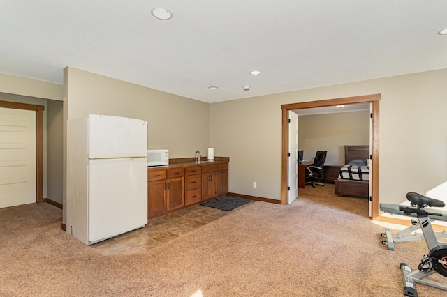 kitchen featuring white appliances, sink, and light carpet