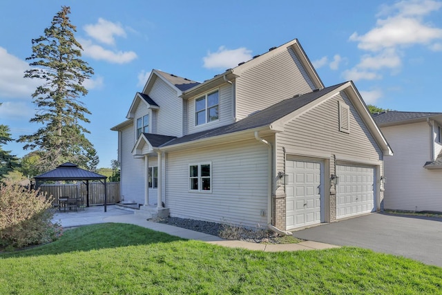 exterior space with a garage, a gazebo, and a yard