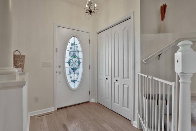 entrance foyer with light hardwood / wood-style flooring and a chandelier