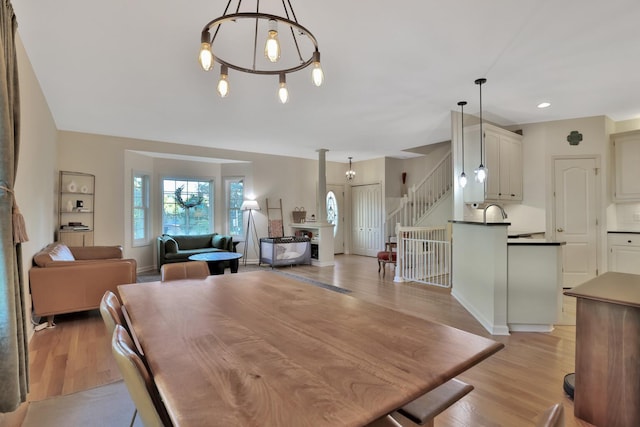 dining space with an inviting chandelier and light hardwood / wood-style flooring