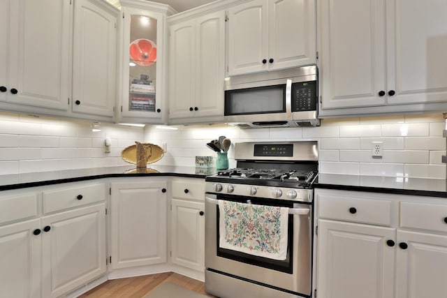 kitchen featuring appliances with stainless steel finishes, tasteful backsplash, and white cabinetry