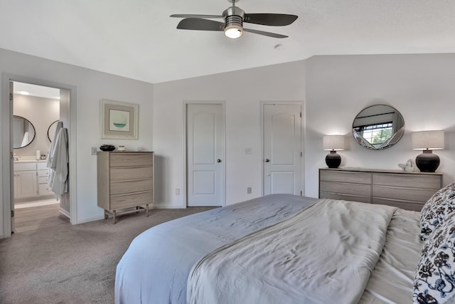 carpeted bedroom with vaulted ceiling, ceiling fan, and ensuite bathroom