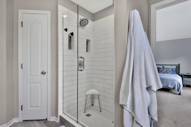 bathroom with hardwood / wood-style floors and a shower with door