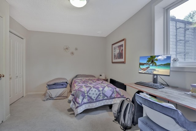 bedroom with light colored carpet and a closet