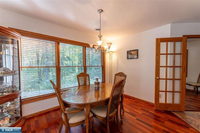 dining space with a notable chandelier and dark hardwood / wood-style floors