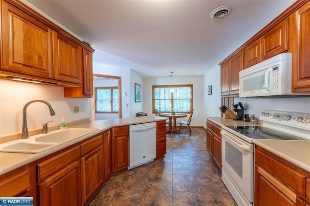 kitchen featuring hanging light fixtures, sink, and white appliances