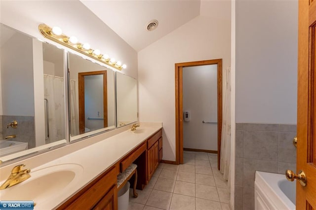 bathroom with tile walls, tile patterned flooring, a washtub, lofted ceiling, and vanity