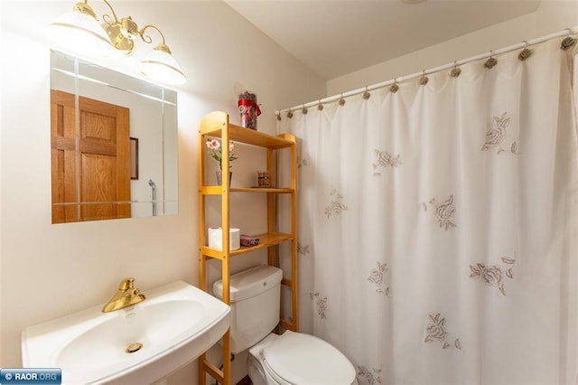 bathroom featuring a shower with curtain, sink, and toilet