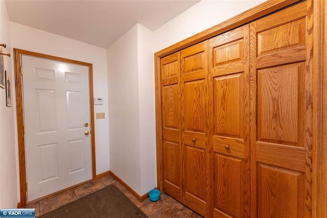 entryway with dark tile patterned floors