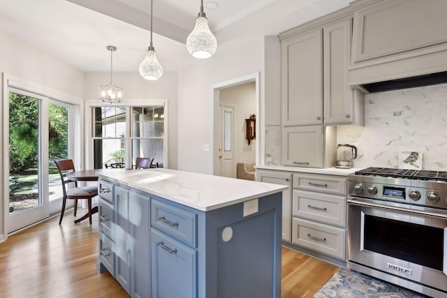 kitchen with hanging light fixtures, a center island, a healthy amount of sunlight, decorative backsplash, and gas range