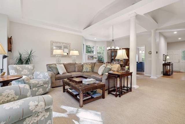 living room featuring an inviting chandelier, light carpet, and ornate columns