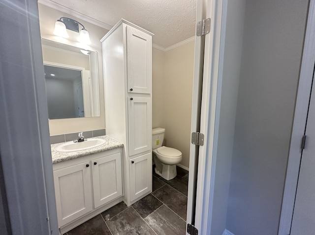 bathroom featuring vanity, crown molding, toilet, and a textured ceiling