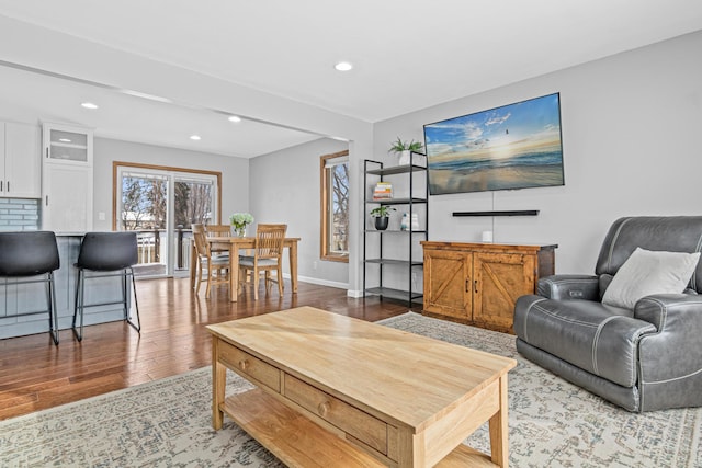 living room featuring baseboards, wood finished floors, and recessed lighting