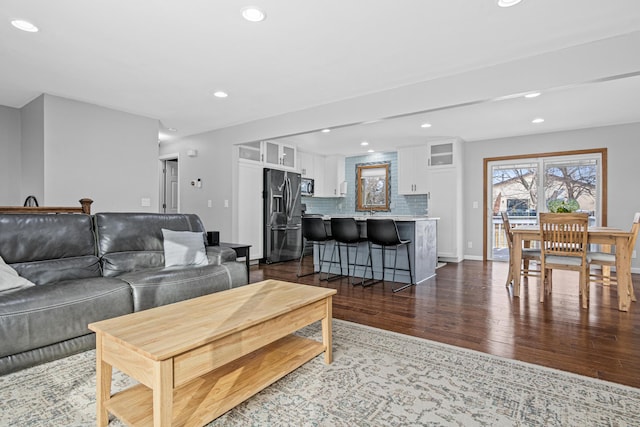 living room featuring baseboards, dark wood-style flooring, and recessed lighting