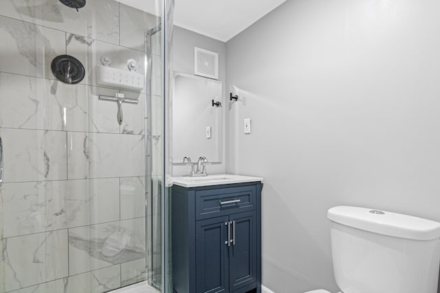 bathroom featuring toilet, a shower stall, vanity, and baseboards