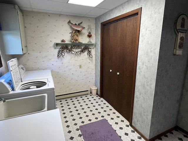 washroom with cabinets, a baseboard radiator, sink, and washing machine and clothes dryer