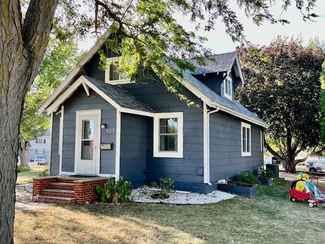 view of front of property with a front lawn and central air condition unit