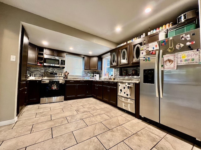 kitchen featuring backsplash, dark brown cabinets, sink, and stainless steel appliances