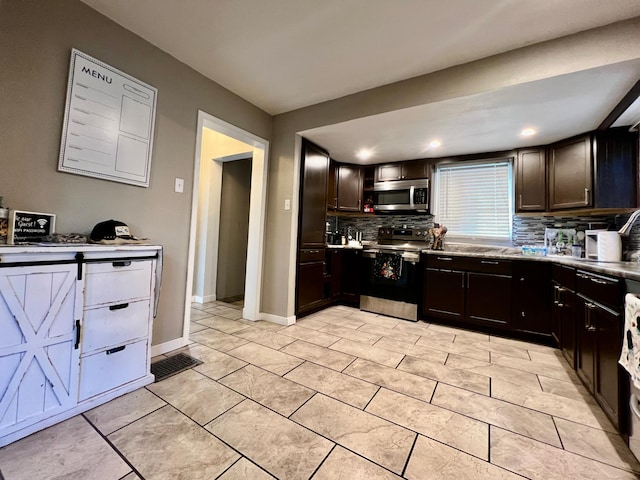 kitchen featuring decorative backsplash, stainless steel appliances, dark brown cabinetry, and a barn door