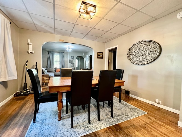 dining room featuring wood-type flooring and a paneled ceiling