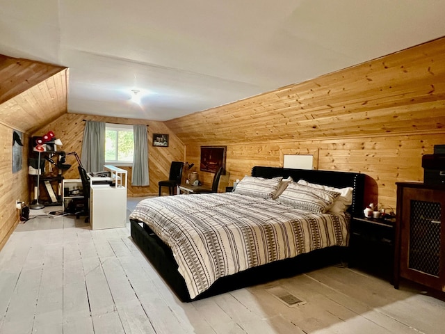 bedroom with wooden walls, lofted ceiling, and light wood-type flooring