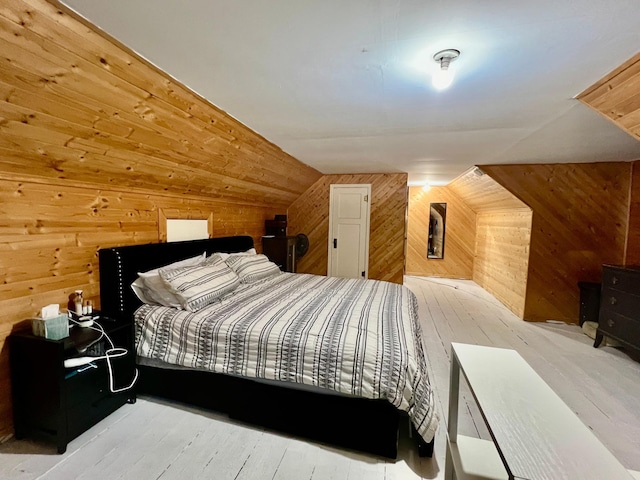 bedroom with light wood-type flooring, wooden walls, and vaulted ceiling