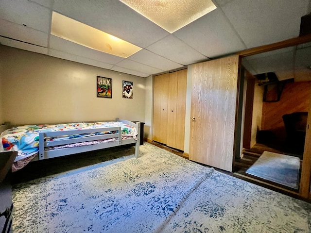 bedroom with wooden walls and a paneled ceiling