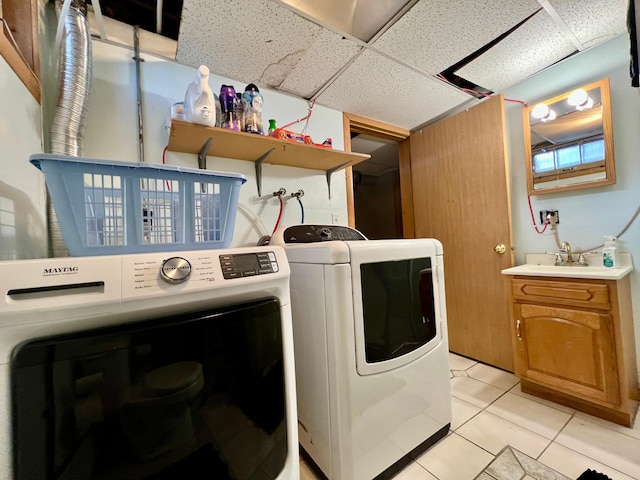 laundry area featuring cabinets, light tile patterned flooring, sink, and independent washer and dryer